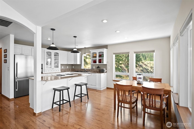 144 W Airport Loop, Seven Bays, WA 99122 - dining area featuring recessed lighting, light wood-style flooring, and arched walkways
