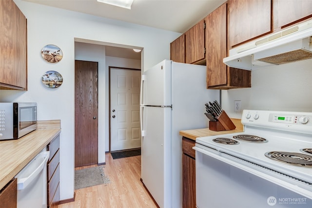 1102 8th St NE Unit 22, Auburn, WA 98002 - kitchen with white appliances, under cabinet range hood, light countertops, light wood-style flooring, and brown cabinets