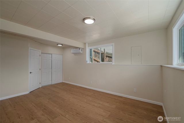 2117 S Majestic Dr, East Wenatchee, WA 98802 - unfurnished bedroom featuring a wall mounted AC, multiple windows, wood finished floors, and electric panel