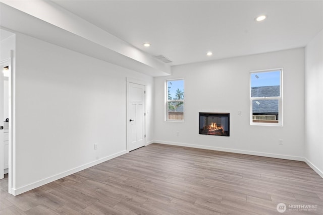 7812 S Sheridan Ave, Tacoma, WA 98408 - unfurnished living room featuring wood finished floors, a glass covered fireplace, plenty of natural light, and recessed lighting