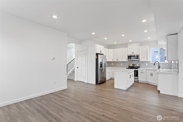 7812 S Sheridan Ave, Tacoma, WA 98408 - kitchen featuring appliances with stainless steel finishes, tasteful backsplash, light wood-style floors, recessed lighting, and light countertops