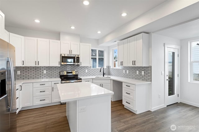 7812 S Sheridan Ave, Tacoma, WA 98408 - kitchen featuring appliances with stainless steel finishes, plenty of natural light, light countertops, dark wood-type flooring, and recessed lighting