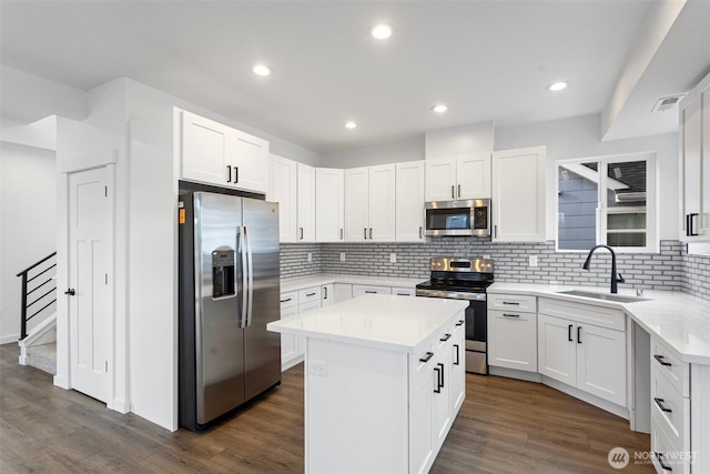7812 S Sheridan Ave, Tacoma, WA 98408 - kitchen featuring stainless steel appliances, a center island, tasteful backsplash, white cabinets, and dark wood-style flooring