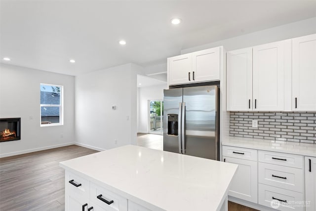 7812 S Sheridan Ave, Tacoma, WA 98408 - kitchen featuring stainless steel fridge, recessed lighting, decorative backsplash, wood finished floors, and white cabinets