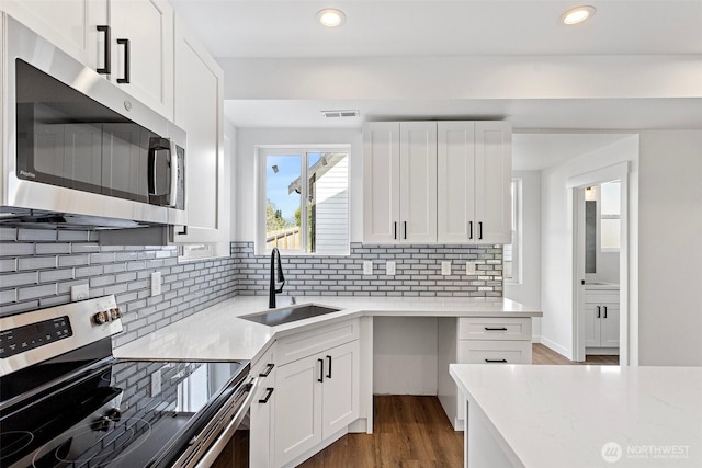 7812 S Sheridan Ave, Tacoma, WA 98408 - kitchen featuring stainless steel appliances, white cabinets, decorative backsplash, recessed lighting, and wood finished floors