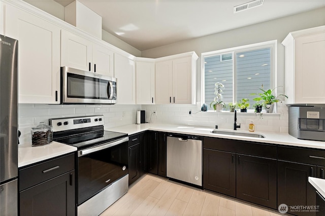16712 8th Ave E, Spanaway, WA 98387 - kitchen with appliances with stainless steel finishes, white cabinets, backsplash, and light countertops