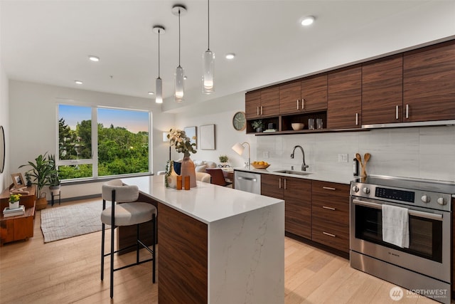 11903 NE 128th St Unit 612, Kirkland, WA 98034 - kitchen featuring stainless steel appliances, open shelves, light wood-style flooring, light countertops, and a breakfast bar