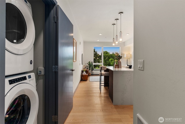 11903 NE 128th St Unit 612, Kirkland, WA 98034 - washroom with stacked washer and clothes dryer, light wood-style floors, and recessed lighting