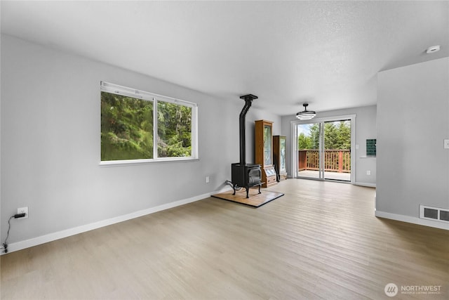 60 E Olyview Pl, Grapeview, WA 98546 - unfurnished living room featuring a wood stove and wood finished floors