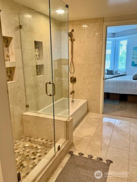 10047 Main St Unit 319, Bellevue, WA 98004 - bathroom with tiled shower, ensuite bath, tile patterned floors, and a tub to relax in