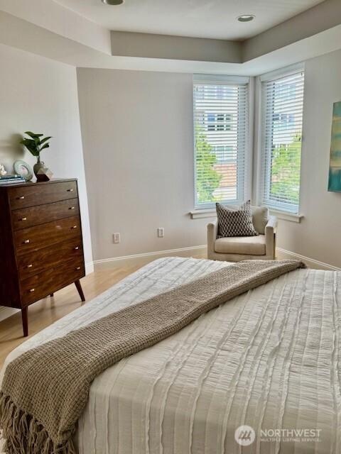 10047 Main St Unit 319, Bellevue, WA 98004 - bedroom with wood finished floors and a raised ceiling