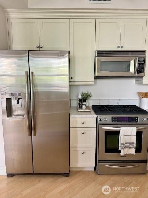 10047 Main St Unit 319, Bellevue, WA 98004 - kitchen featuring appliances with stainless steel finishes, light wood finished floors, and light countertops