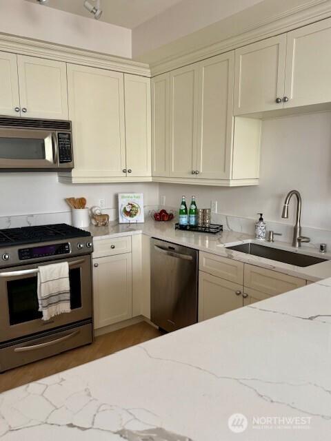 10047 Main St Unit 319, Bellevue, WA 98004 - kitchen with stainless steel appliances, light stone countertops, and light wood finished floors