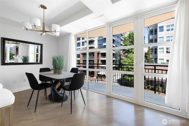 10047 Main St Unit 319, Bellevue, WA 98004 - dining room featuring healthy amount of natural light, a chandelier, and wood finished floors