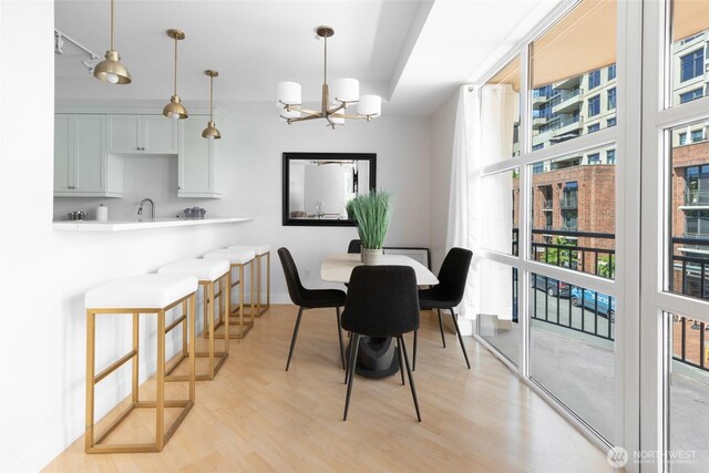 10047 Main St Unit 319, Bellevue, WA 98004 - dining space with light wood-style floors and a chandelier
