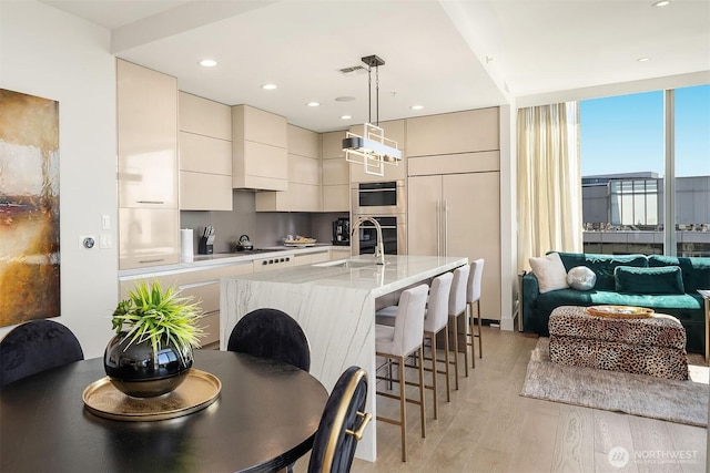 10650 NE 9th Pl Unit 2524, Bellevue, WA 98004 - kitchen with modern cabinets, light wood-type flooring, a breakfast bar, open floor plan, and hanging light fixtures
