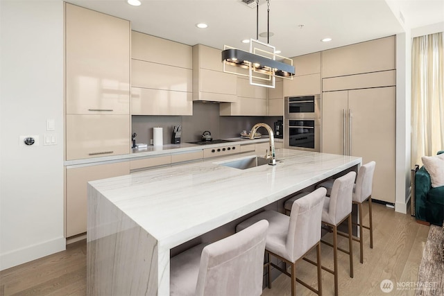 10650 NE 9th Pl Unit 2524, Bellevue, WA 98004 - kitchen featuring modern cabinets, light wood finished floors, a breakfast bar area, a kitchen island with sink, and recessed lighting