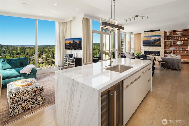 10650 NE 9th Pl Unit 2524, Bellevue, WA 98004 - kitchen with beverage cooler, light wood finished floors, white cabinetry, and open floor plan