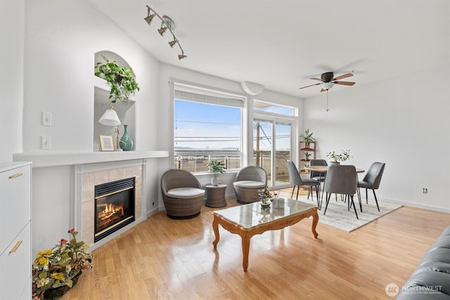 2420 Grand Ave Unit 103, Everett, WA 98201 - living area featuring a ceiling fan, wood finished floors, and a tiled fireplace