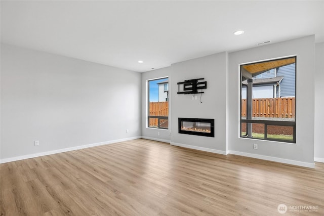 298 Hovey St, Buckley, WA 98321 - unfurnished living room featuring a glass covered fireplace, light wood-style floors, healthy amount of natural light, and recessed lighting