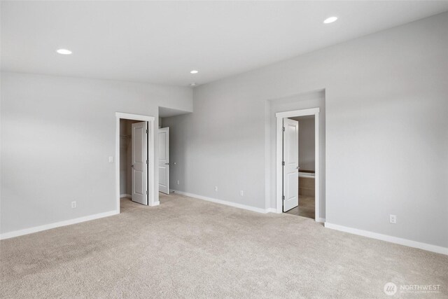 298 Hovey St, Buckley, WA 98321 - unfurnished bedroom featuring light colored carpet, recessed lighting, a spacious closet, ensuite bathroom, and lofted ceiling