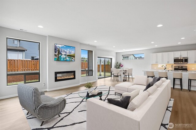 298 Hovey St, Buckley, WA 98321 - living area featuring light wood-style floors, a glass covered fireplace, and recessed lighting
