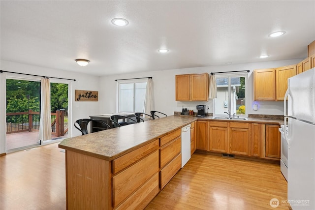 17230 Heather Ln SE, Yelm, WA 98597 - kitchen featuring white appliances, a peninsula, plenty of natural light, light wood-style flooring, and recessed lighting