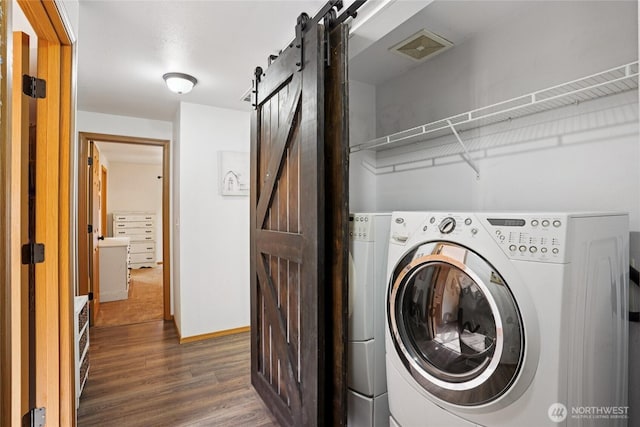 17230 Heather Ln SE, Yelm, WA 98597 - laundry area featuring a barn door, dark wood-style flooring, and separate washer and dryer