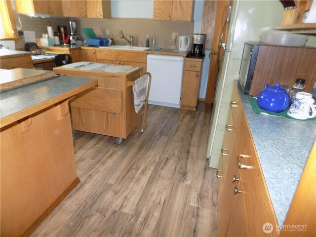 361 Rehmke Rd, Tonasket, WA 98855 - kitchen featuring dishwasher, backsplash, light wood finished floors, and brown cabinets