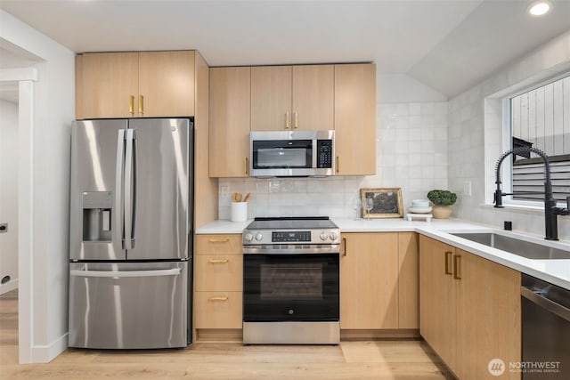 840 NE 100th St Unit A, Seattle, WA 98125 - kitchen with stainless steel appliances, light brown cabinets, light wood-type flooring, light countertops, and vaulted ceiling