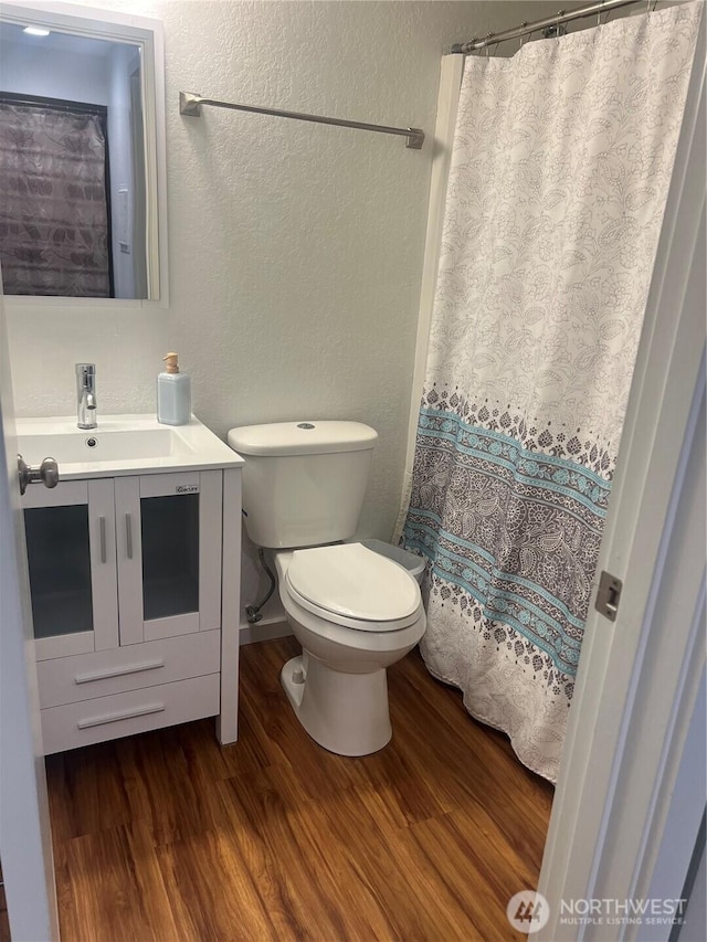 4800 200th St SW Unit E205, Lynnwood, WA 98036 - bathroom with wood finished floors, vanity, a shower with shower curtain, and a textured wall