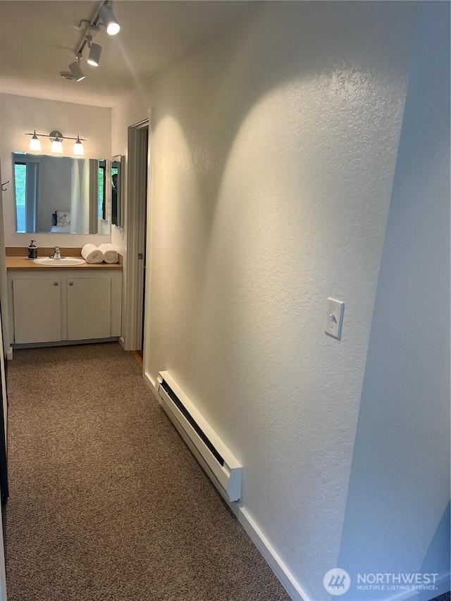 4800 200th St SW Unit E205, Lynnwood, WA 98036 - corridor with a baseboard radiator, carpet, track lighting, and a textured wall