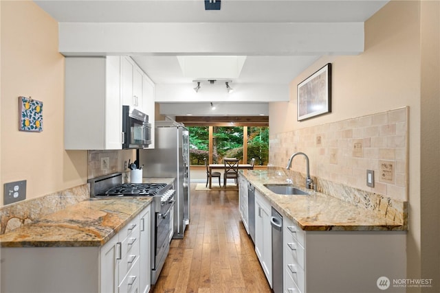 7623 NE 123rd St, Kirkland, WA 98034 - kitchen with stainless steel appliances, white cabinetry, decorative backsplash, light wood-style flooring, and light stone counters