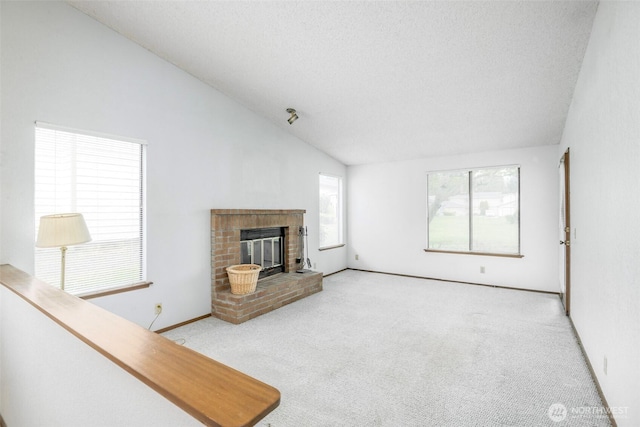 25036 110th Ave SE Unit 25A, Kent, WA 98030 - unfurnished living room featuring carpet, lofted ceiling, a fireplace, and a textured ceiling
