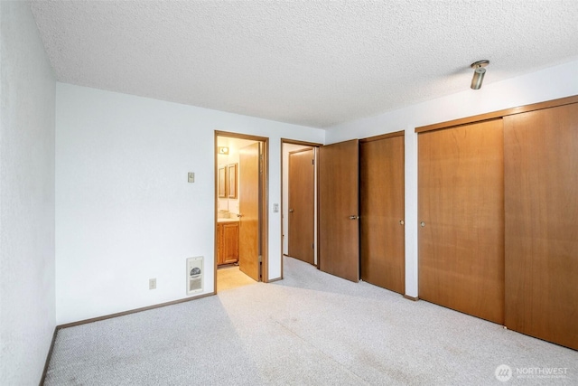 25036 110th Ave SE Unit 25A, Kent, WA 98030 - unfurnished bedroom featuring multiple closets, carpet flooring, a textured ceiling, and ensuite bath