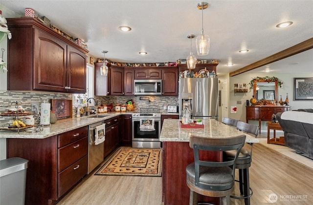 327 N Grape Dr, Moses Lake, WA 98837 - kitchen featuring appliances with stainless steel finishes, light wood-style flooring, decorative backsplash, light stone counters, and recessed lighting