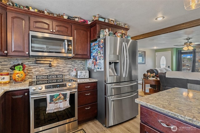 327 N Grape Dr, Moses Lake, WA 98837 - kitchen with appliances with stainless steel finishes, tasteful backsplash, ceiling fan, light wood-style floors, and a textured ceiling