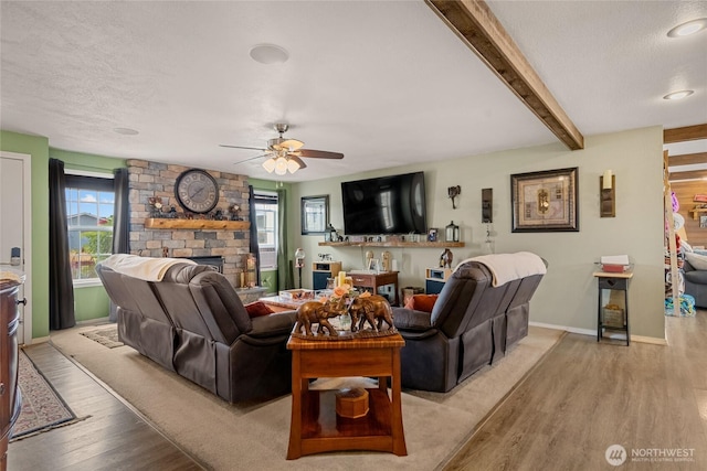 327 N Grape Dr, Moses Lake, WA 98837 - living area with wood finished floors, healthy amount of natural light, a brick fireplace, a ceiling fan, and a textured ceiling