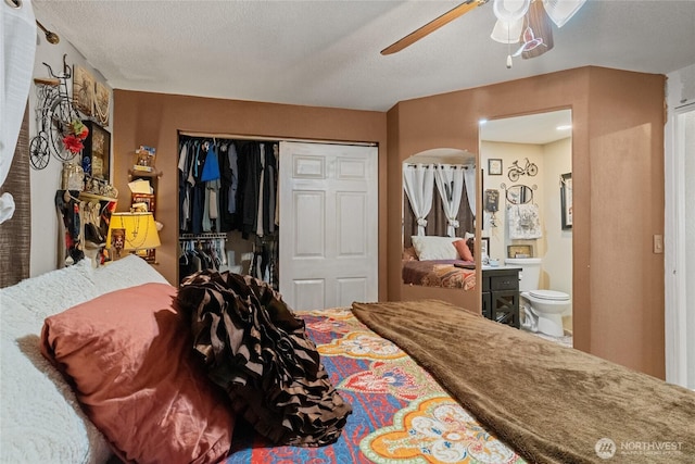 327 N Grape Dr, Moses Lake, WA 98837 - bedroom with arched walkways, a closet, ensuite bathroom, a ceiling fan, and a textured ceiling
