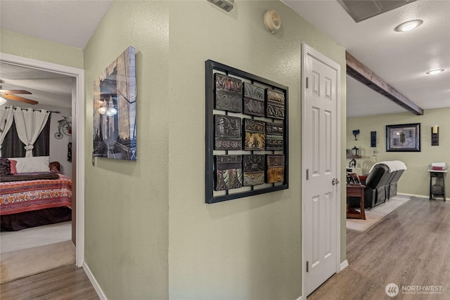 327 N Grape Dr, Moses Lake, WA 98837 - corridor with wood finished floors, beam ceiling, and a textured wall