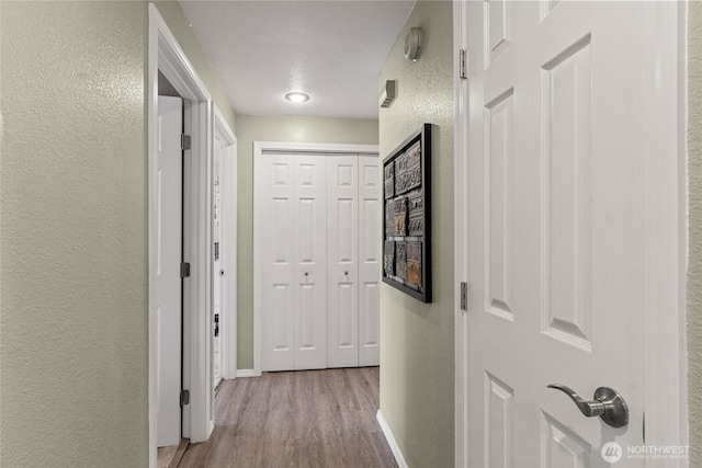 327 N Grape Dr, Moses Lake, WA 98837 - hallway featuring a textured wall and wood finished floors