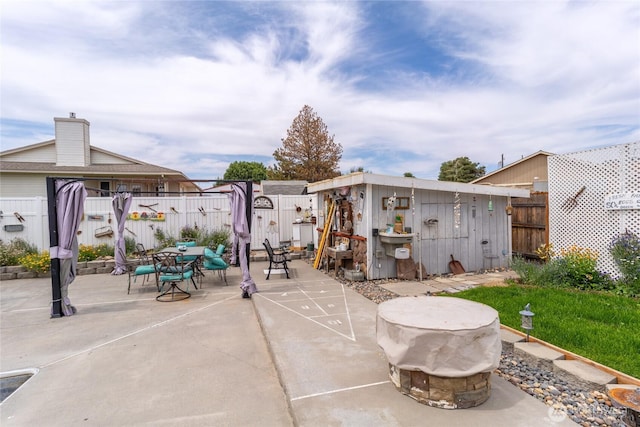 327 N Grape Dr, Moses Lake, WA 98837 - fenced backyard featuring outdoor dining area, a storage unit, and a patio area