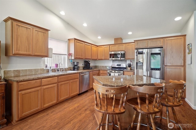 16 NW 23rd St, Battle Ground, WA 98604 - kitchen with stainless steel appliances, lofted ceiling, wood finished floors, a kitchen breakfast bar, and recessed lighting