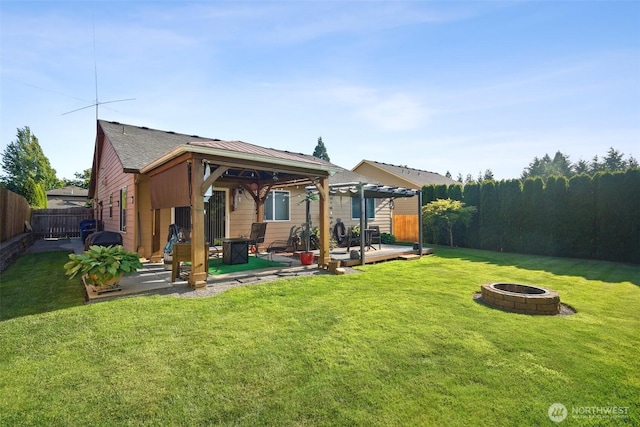 16 NW 23rd St, Battle Ground, WA 98604 - rear view of house featuring an outdoor fire pit, a fenced backyard, a gazebo, a deck, and roof with shingles