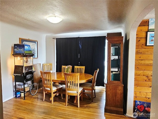 591 Division Ave, Morton, WA 98356 - dining room featuring arched walkways, a textured ceiling, and light wood-type flooring
