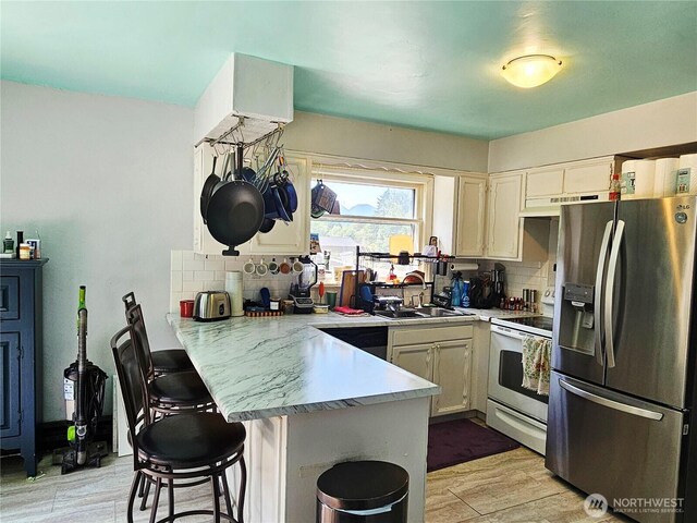 591 Division Ave, Morton, WA 98356 - kitchen featuring stainless steel fridge, white electric stove, a peninsula, under cabinet range hood, and tasteful backsplash