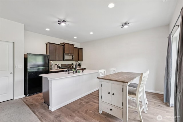 32803 Marguerite Ln, Sultan, WA 98294 - kitchen with black appliances, dark brown cabinets, light wood finished floors, light countertops, and recessed lighting