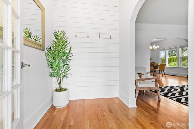 1584 Main St, Lynden, WA 98264 - hall featuring arched walkways, light wood-style flooring, a chandelier, and wooden walls