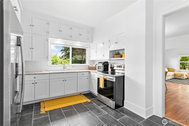 1584 Main St, Lynden, WA 98264 - kitchen featuring appliances with stainless steel finishes, white cabinets, decorative backsplash, and open shelves