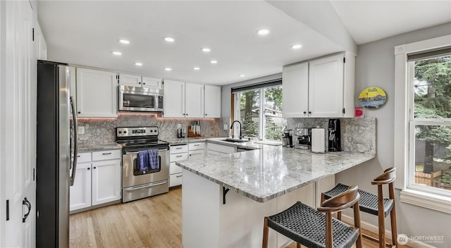 12350 SE 96th Pl, Renton, WA 98056 - kitchen with stainless steel appliances, a peninsula, plenty of natural light, recessed lighting, and tasteful backsplash